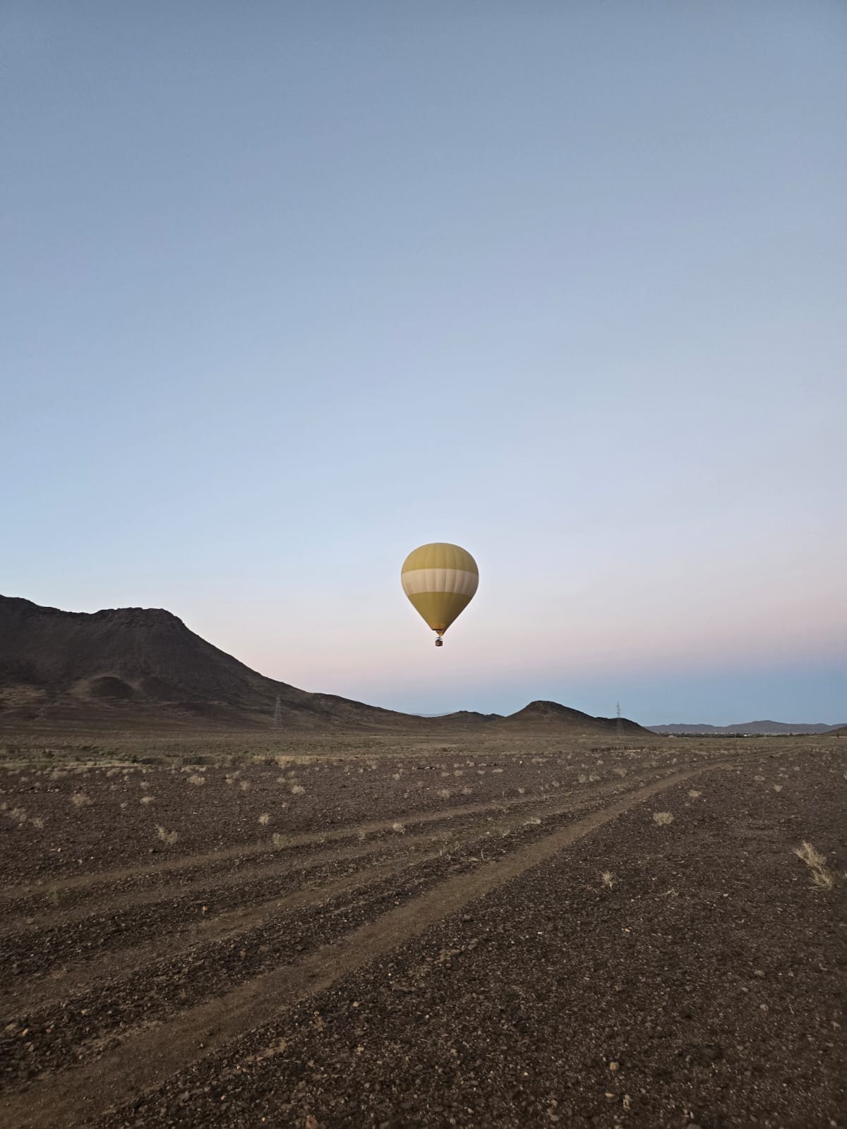 Guests flying in a hot air balloon above the southern Moroccan valleys at dawn